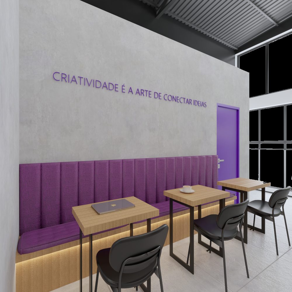 Lounge com banco corrido estofado em roxo, mesas de madeira e cadeiras pretas, junto a uma parede de concreto com a frase Criatividade é a arte de conectar ideias