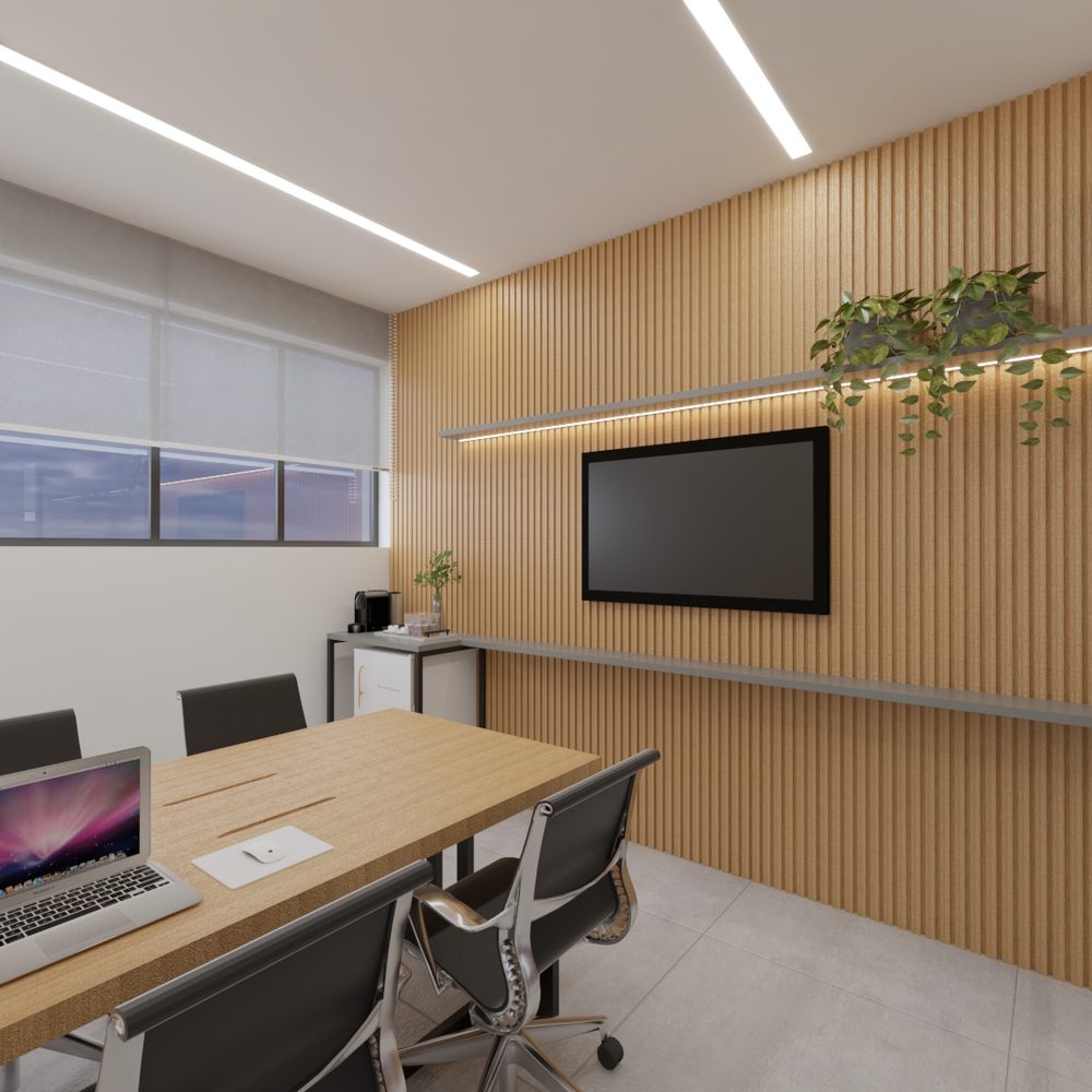 Sala privativa com mesa de trabalho, notebooks, televisão na parede de ripas de madeira, janela com persiana e plantas penduradas